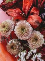 bouquet di diversi bellissimi fiori luminosi, foto verticale. elemento interno di design decorativo, primo piano, carta da parati. pianta della natura, colori rosso e rosa, regalo