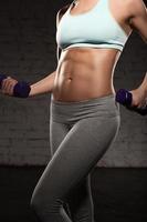 fitness donna, corpo muscoloso, allenamento, manubri, addominali, addominali foto