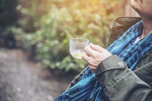 l'uomo felice beve la tazza di tè calda - la gente asiatica con la bevanda calda del tè si rilassa il concetto foto