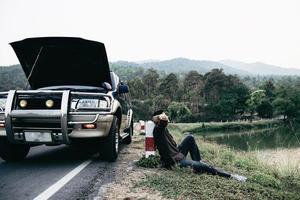 l'uomo cerca di risolvere un problema al motore di un'auto su una strada locale chiang mai thailandia - persone con problemi di auto concetto di trasporto foto