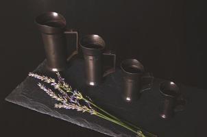misurini vintage di natura morta impostati su tavola di pietra grezza nera foto