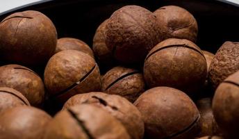 noci di macadamia intere in banda nera. spuntino vegetariano sano. foto ravvicinata. dieta vegetale.