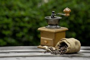 macinacaffè vintage. vecchio macinino da caffè in legno e metallo retrò azionato a mano. macinacaffè manuale per macinare i chicchi di caffè. sullo sfondo di legno vecchio. foto