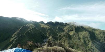 montagne verdi e bellissime nuvole di cielo sotto il cielo blu foto