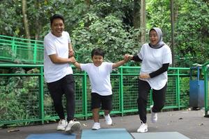 famiglia asiatica divertendosi esercitando lo sport insieme al parco. foto