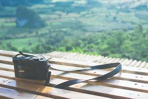 la fotocamera mirrorless ha messo il tavolo di legno con una splendida vista panoramica sotto al mattino. foto