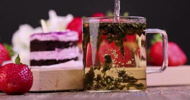 preparare foglie di tè con fiori di gelsomino in una tazza foto