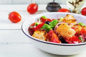 insalata tradizionale italiana panzanella toscana con pomodoro, pane e olive sottaceto foto