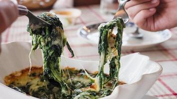 persone che mangiano spinaci ricetta cuocere il formaggio - persone con il famoso delizioso concetto di cibo italiano foto