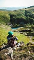 turista femminile sullo sfondo delle montagne verdi e del lago foto