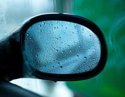 specchietto retrovisore auto con gocce di pioggia foto