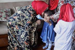 nonna che bacia la nipote durante il lebaran idul fitri day. foto