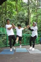 famiglia asiatica divertendosi esercitando lo sport insieme al parco. foto