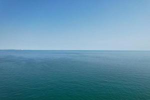 riprese ad alto angolo e vista aerea dell'oceano con barche ad alta velocità, le persone si divertono e si godono il clima più caldo a Bournemouth Beach, di fronte al mare dell'Inghilterra, Regno Unito. foto