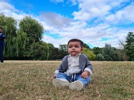 Il simpatico neonato sta posando in un parco pubblico locale di Luton, città dell'Inghilterra, Regno Unito foto
