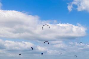 un sacco di attività di kite surf sulla spiaggia del mar baltico di laboe in germania in una giornata di sole. foto