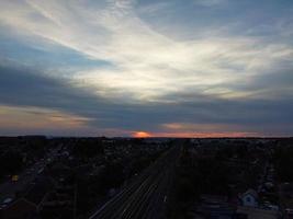 riprese aeree vista dall'alto della città di luton in inghilterra e stazione ferroviaria e treno su binari al tramonto foto