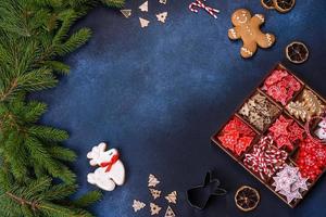 giocattoli di Natale in bianco e rosso in una scatola componibile di legno su uno sfondo di cemento scuro foto