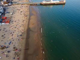 Vista mare ad alto angolo di fronte alla spiaggia con persone a Bournemouth, città dell'Inghilterra, Regno Unito, riprese aeree dell'Oceano Britannico foto