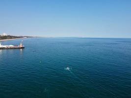 riprese ad alto angolo e vista aerea dell'oceano con barche ad alta velocità, le persone si divertono e si godono il clima più caldo a Bournemouth Beach, di fronte al mare dell'Inghilterra, Regno Unito. foto