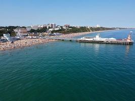 riprese ad alto angolo e vista aerea dell'oceano con barche ad alta velocità, le persone si divertono e si godono il clima più caldo a Bournemouth Beach, di fronte al mare dell'Inghilterra, Regno Unito. foto