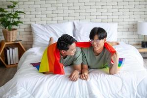 felice coppia gay asiatica che parla insieme e si rilassa a casa sul letto, concetto lgbtq. foto