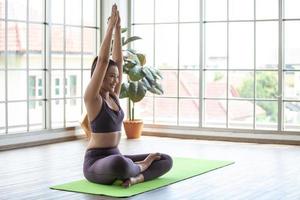 giovane donna asiatica che lavora e fa yoga a casa, concetto sano. foto