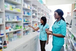 due farmacisti afroamericani che lavorano in farmacia presso la farmacia dell'ospedale. assistenza sanitaria africana. foto