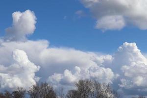 belle formazioni di nuvole bianche e soffici in un cielo estivo blu intenso foto