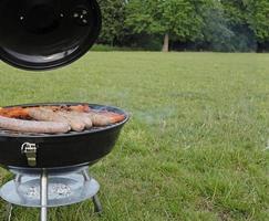 stagione del barbecue - griglia per barbecue con bistecche e salsicce nel parco foto