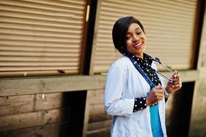 medico afroamericano femmina con stetoscopio poste all'aperto. foto
