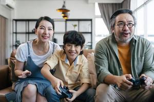 famiglia asiatica che gioca al videogioco a casa foto