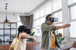 padre e figlio asiatici che giocano usando le cuffie vr. foto