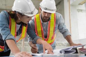 lavoro di ingegnere in cantiere parlando e discutendo sul documento foto