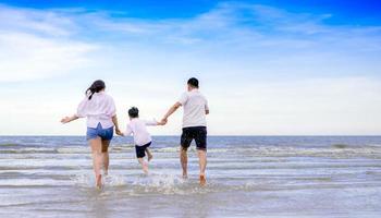 famiglia felice che salta sulla spiaggia foto