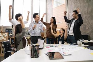 gli uomini d'affari stanno lavorando su un laptop sul posto di lavoro dell'ufficio creativo. riunione del team creativo asiatico e concetto di idee per la pianificazione del design funzionante foto