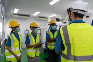 gli operai si incontrano prima del lavoro e indossano una maschera foto