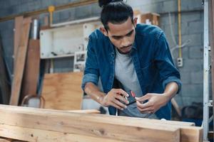 giovane falegname asiatico che lavora nel laboratorio di falegnameria di woodcraft. foto