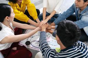 gruppo di uomini d'affari creativi del team asiatico si uniscono al concetto di lavoro di squadra di partenariato per mani foto