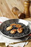 paella di riso nero con gamberi foto