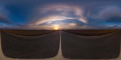 panorama sferico completo senza soluzione di continuità vista angolare a 360 gradi su strada asfaltata senza traffico tra i campi la sera prima del tramonto con cielo nuvoloso. Panorama a 360 gradi in proiezione equirettangolare, contenuto vr ar foto