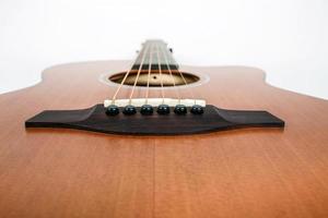 struttura in legno del ponte inferiore di una chitarra acustica a sei corde su sfondo bianco. forma di chitarra foto