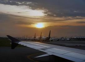 aeroporto con molti aeroplani al bel tramonto, flotta di aeromobili parcheggiata presso la pista di rullaggio dell'aeroporto internazionale di Bangkok foto