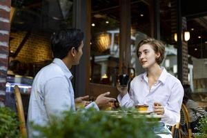 la coppia ha un appuntamento al caffè bistrot in stile europeo godendosi l'atmosfera mattutina intorno alla piazza della città con pasticceria dolce e tazza di caffè foto