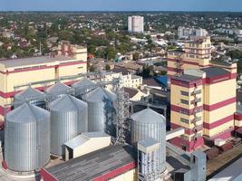 silo agricolo. stoccaggio ed essiccazione di cereali, grano, mais, soia, contro il cielo blu con nuvole. foto