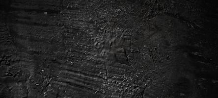 sfondo di pietra nero scuro. trama di cemento nero spaventoso. sfondo muro di pietra. foto