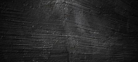sfondo di pietra nero scuro. trama di cemento nero spaventoso. sfondo muro di pietra. foto