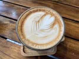 bella tazza di caffè cappuccino con latte art sullo sfondo dello spazio in legno foto