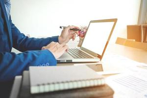 giovane che lavora con il computer portatile sulla sua scrivania in un caffè, le mani dell'uomo che puntano il computer portatile, uomo d'affari sul posto di lavoro. foto