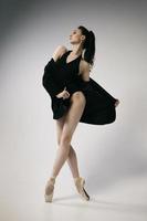 ballerina in body e giacca nera improvvisa coreografie classiche e moderne in uno studio fotografico foto